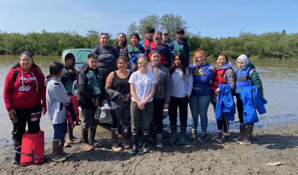 Group of students in front of boat