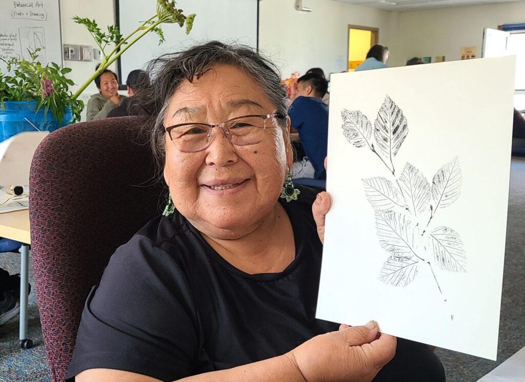 Elder holding a plant print picture