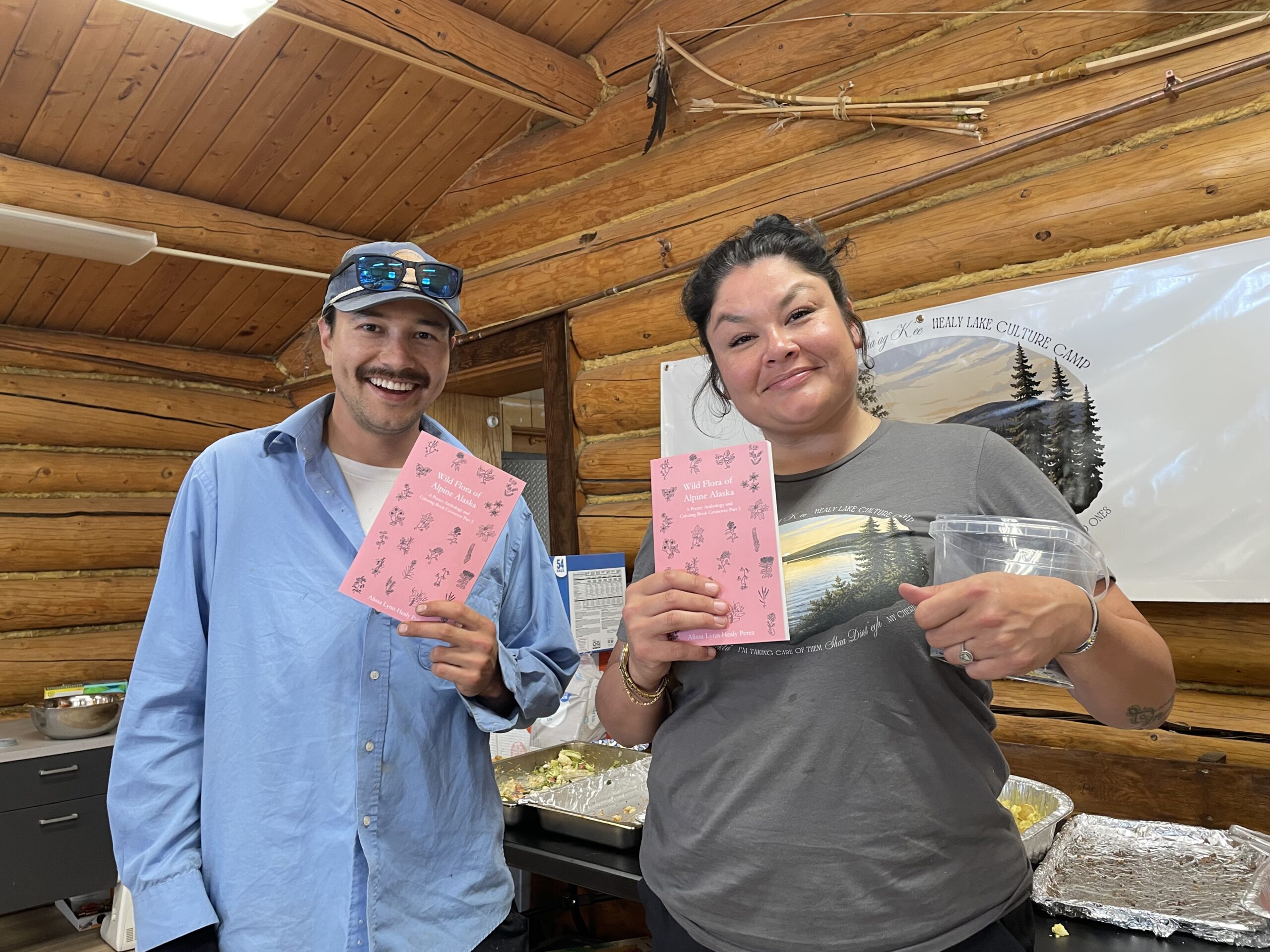 Two people holding and showing a book 